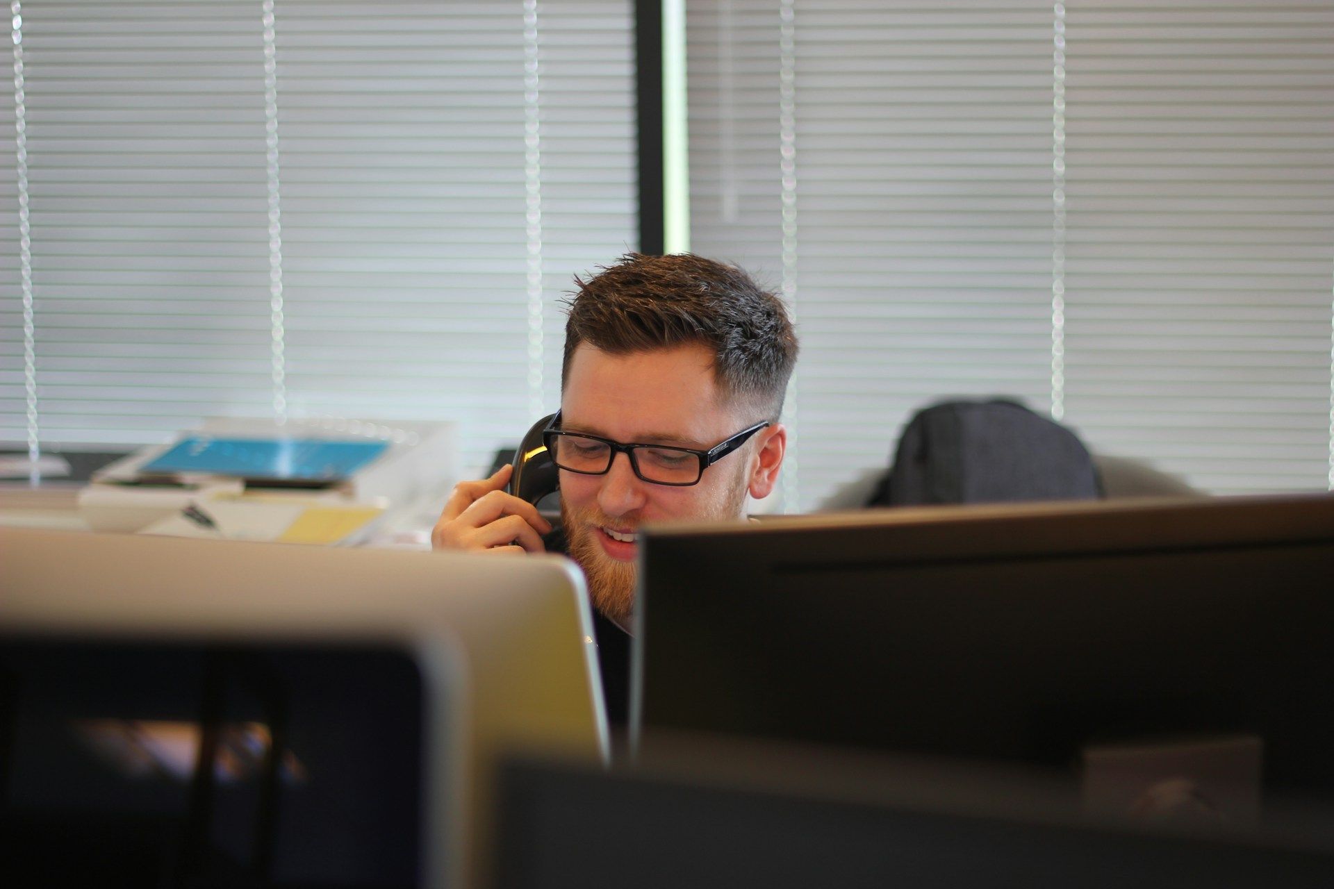 Man in the Office Happily on the Phone